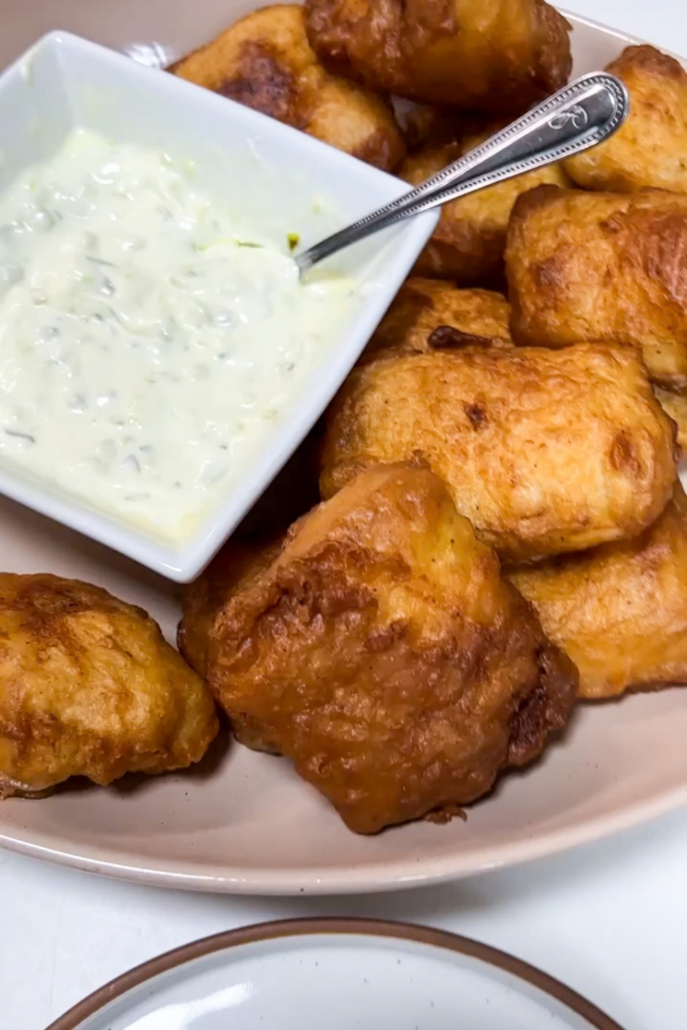 Golden crispy beer battered fish pieces served with dipping sauce