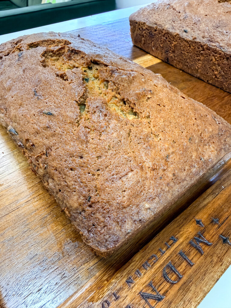 Close-up of finished zucchini bread loaf showing tender crumb with visible flecks of zucchini and spices