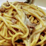a plate of pasta with venison and morel mushrooms and a mushroom gravy