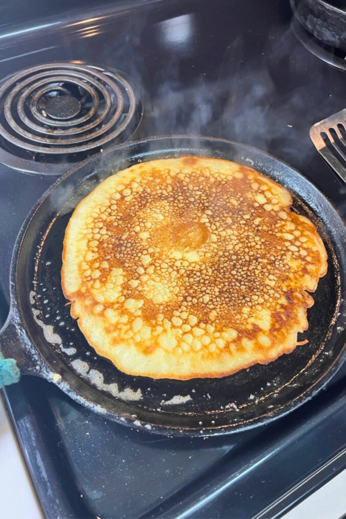 a pancake being cooked in a skillet on a stove