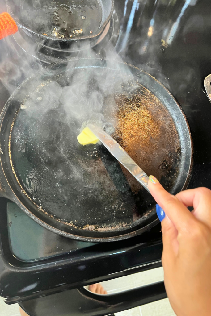 a person is melting butter in a pan on a stove