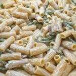 One pot asparagus and bacon rigatoni served in a bowl with parmesan cheese