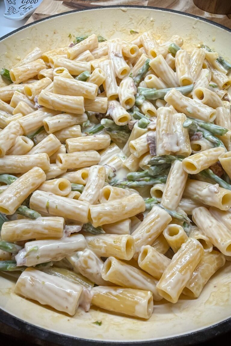 One pot asparagus and bacon rigatoni served in a bowl with parmesan cheese