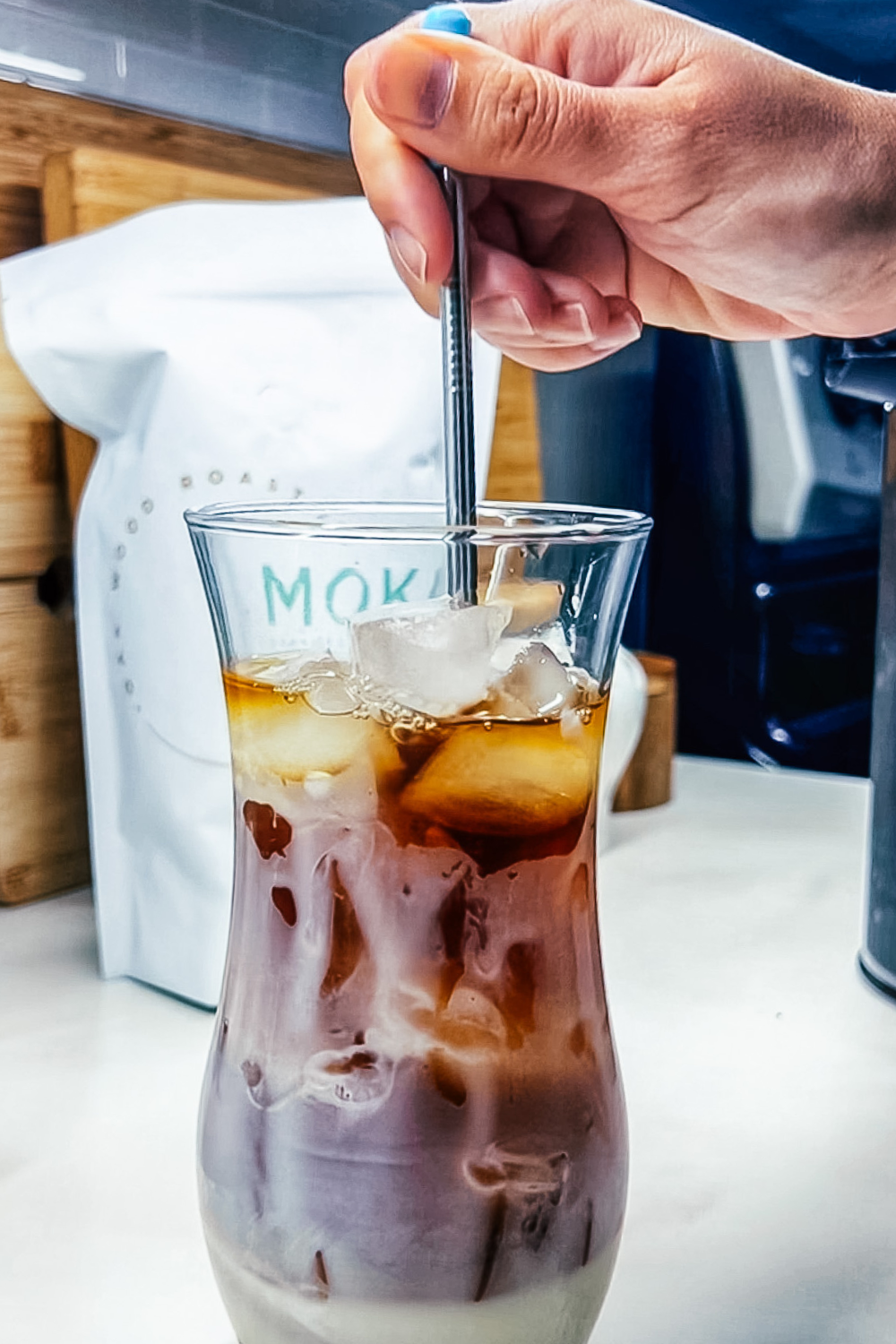 Image of the coffee, ice, and sweetened condensed milk being stirred with the straw.