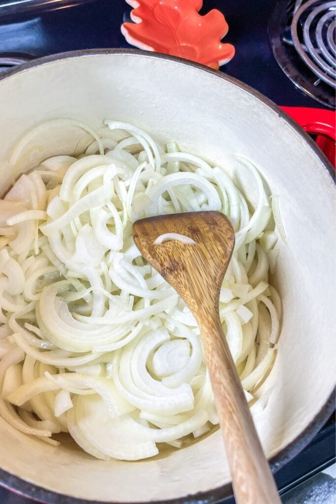 sliced onions in a cast iron pot on the stove