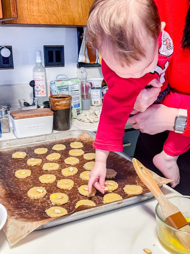 My youngest putting an almond slice on a cookie when she was a baby