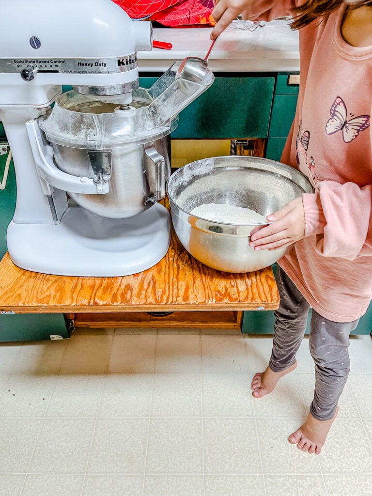One of my daughters slowly adding flour to the wet ingredients in my stand mixer.