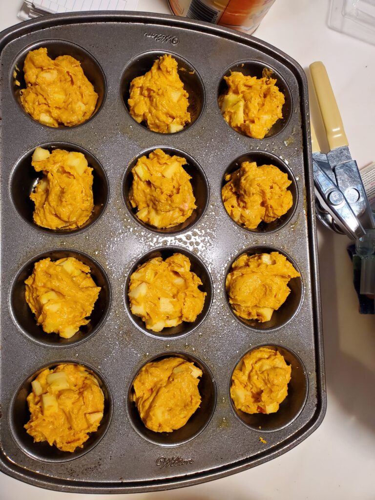 muffins batter in a muffin tin before being baked.