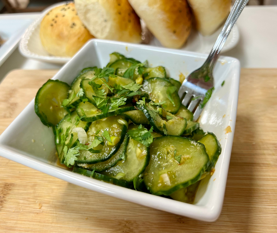 My asian cucumber salad in a square bowl with a fork sitting in the bowl