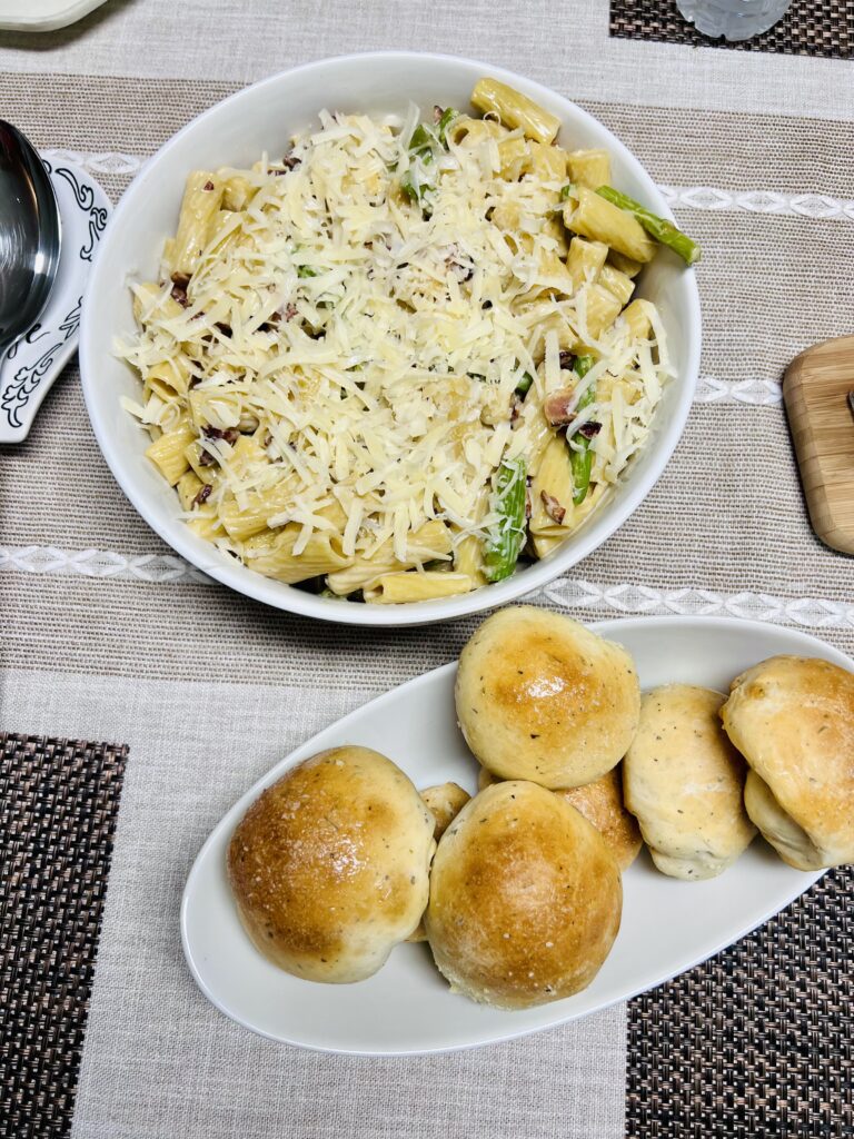 One Pot Bacon and Asparagus Rigatoni next to to homemade rolls