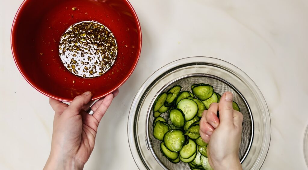 Squeezing the cucumbers. I also have the bowl of dressing near so I can drop the cucumbers in to the bowl afterwards.