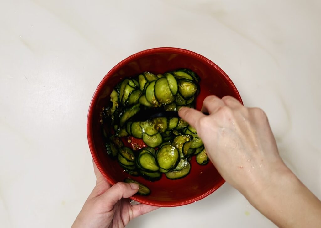 Mixing the cucumbers and salad together.