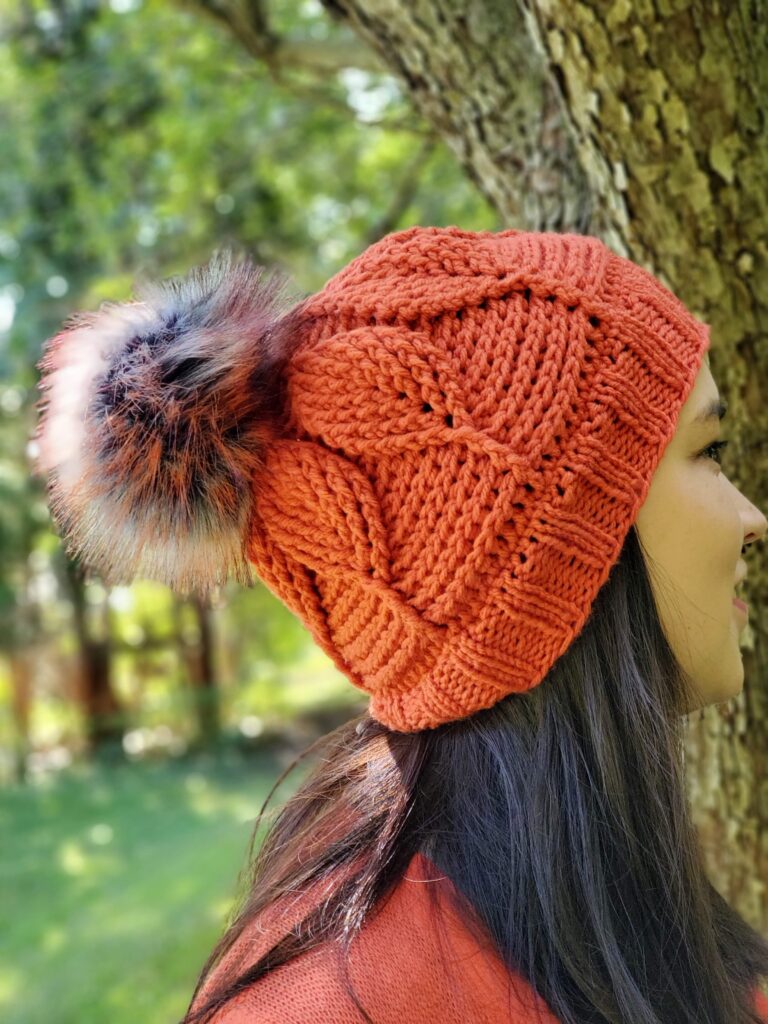 brunette wearing the birch leaf beanie in dark orange