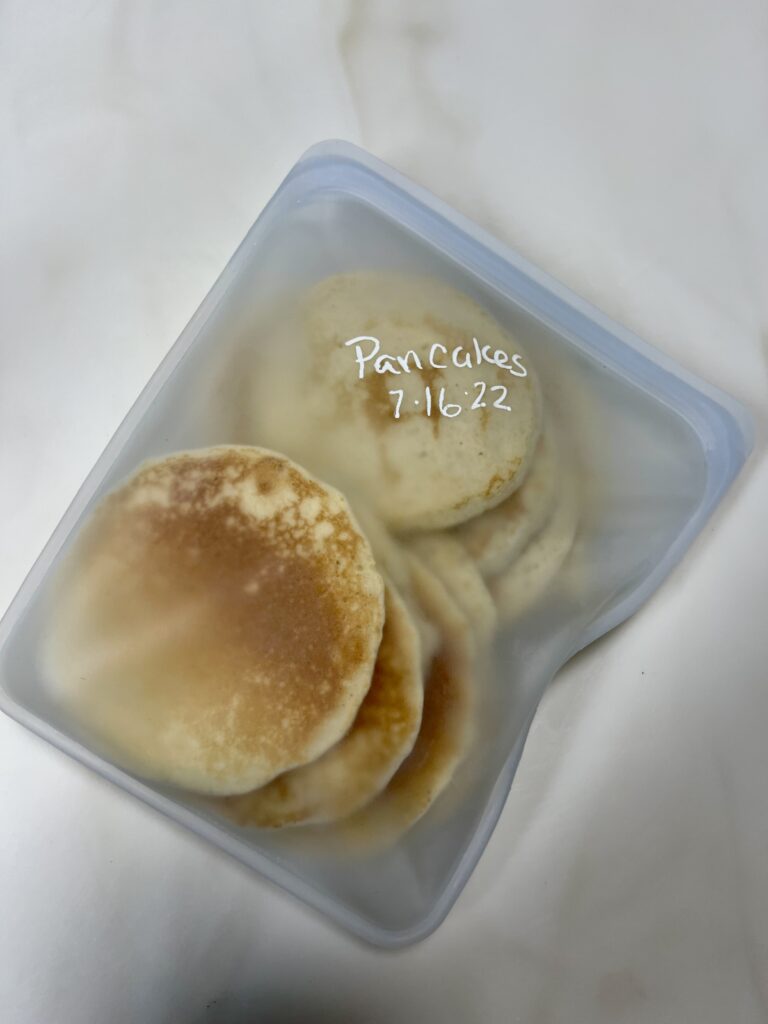 Frozen pancakes in a silicone bag labeled Pancakes with the date made and ready for the freezer.