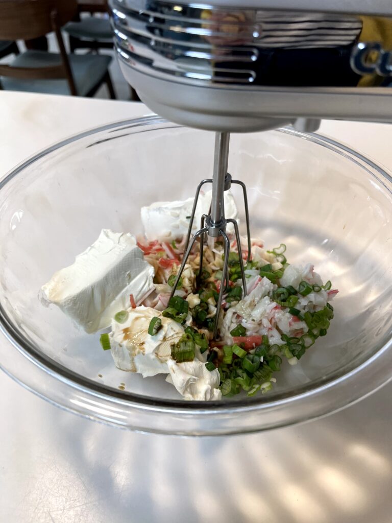 all ingredients in a mixing bowl and a hand mixer ready to "blend" all the ingredients.