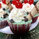 finished cupcake with bright red maraschino cherries on top.