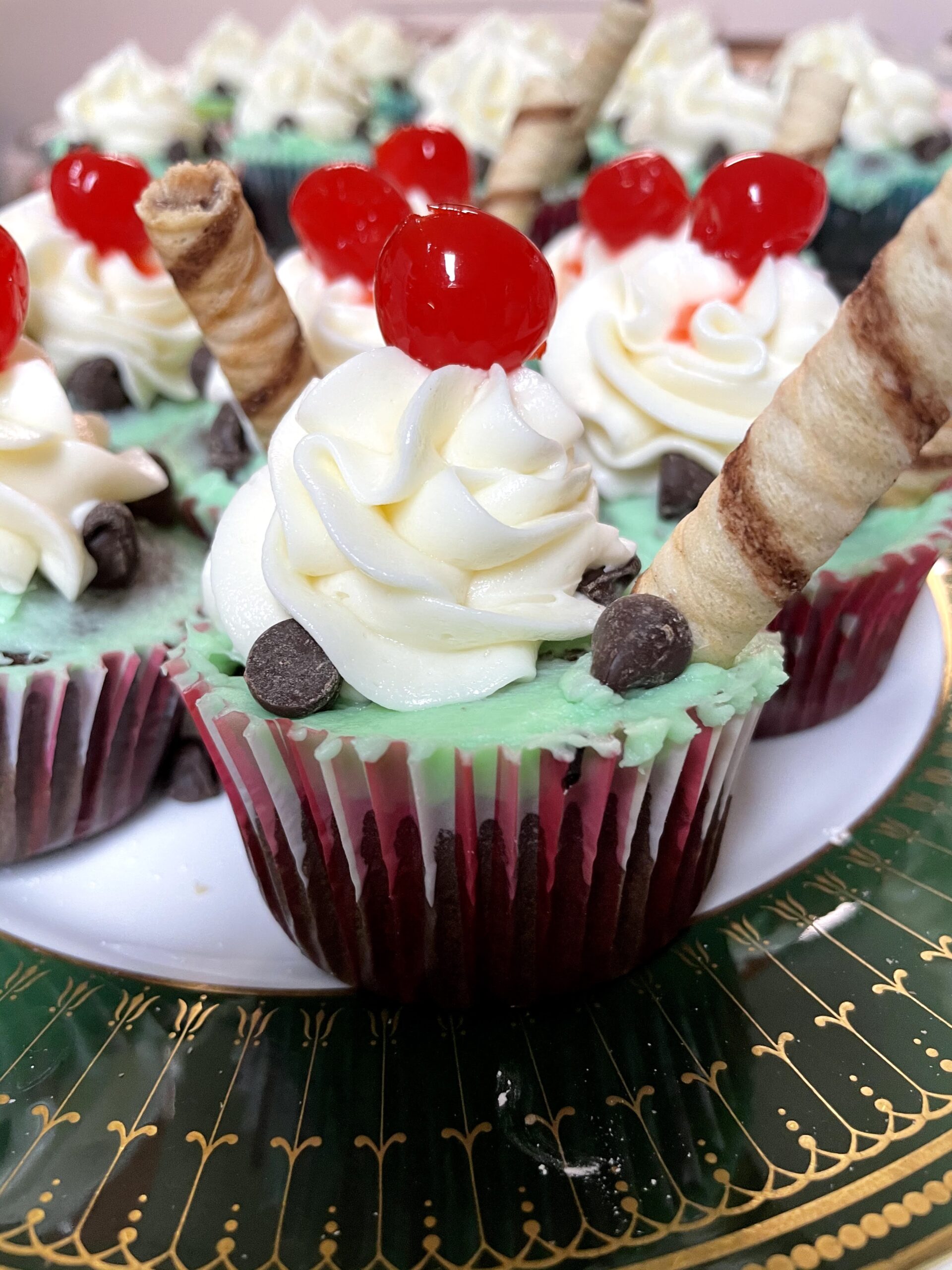 finished cupcake with bright red maraschino cherries on top.