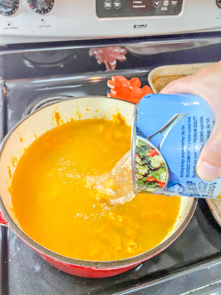 adding broth to the mashed squash