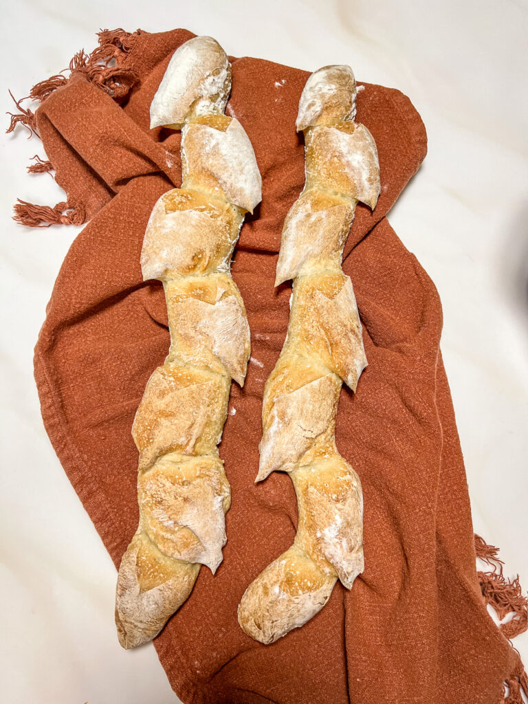 Header image. Baguettes in the shape of Pain d'épi (or wheat stock shape) on a burnt orange towel.