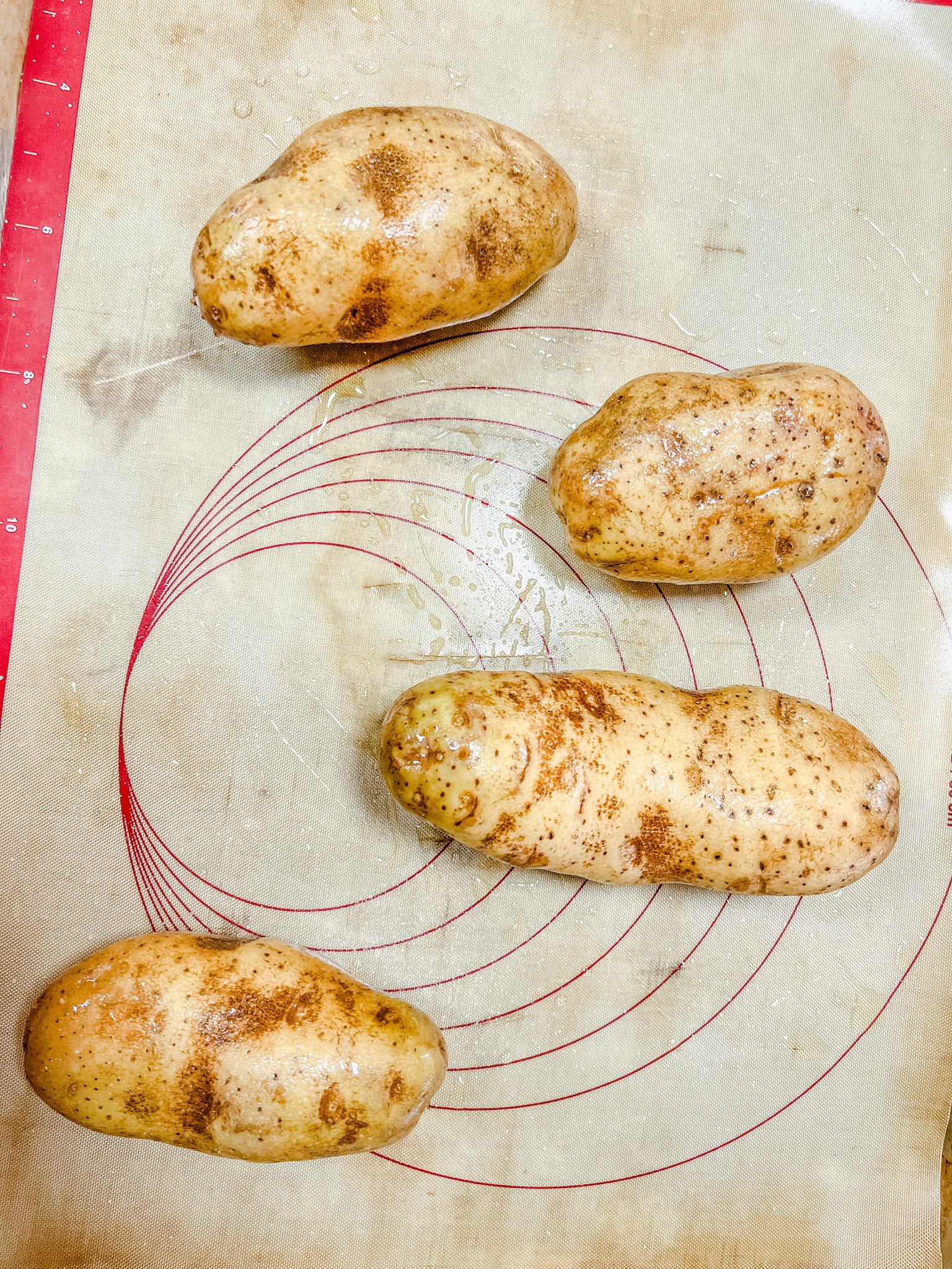 Baked potato with oil and salt on it ready for the oven.