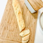 French baguette (sliced at the end in an angle) on a bamboo cutting board