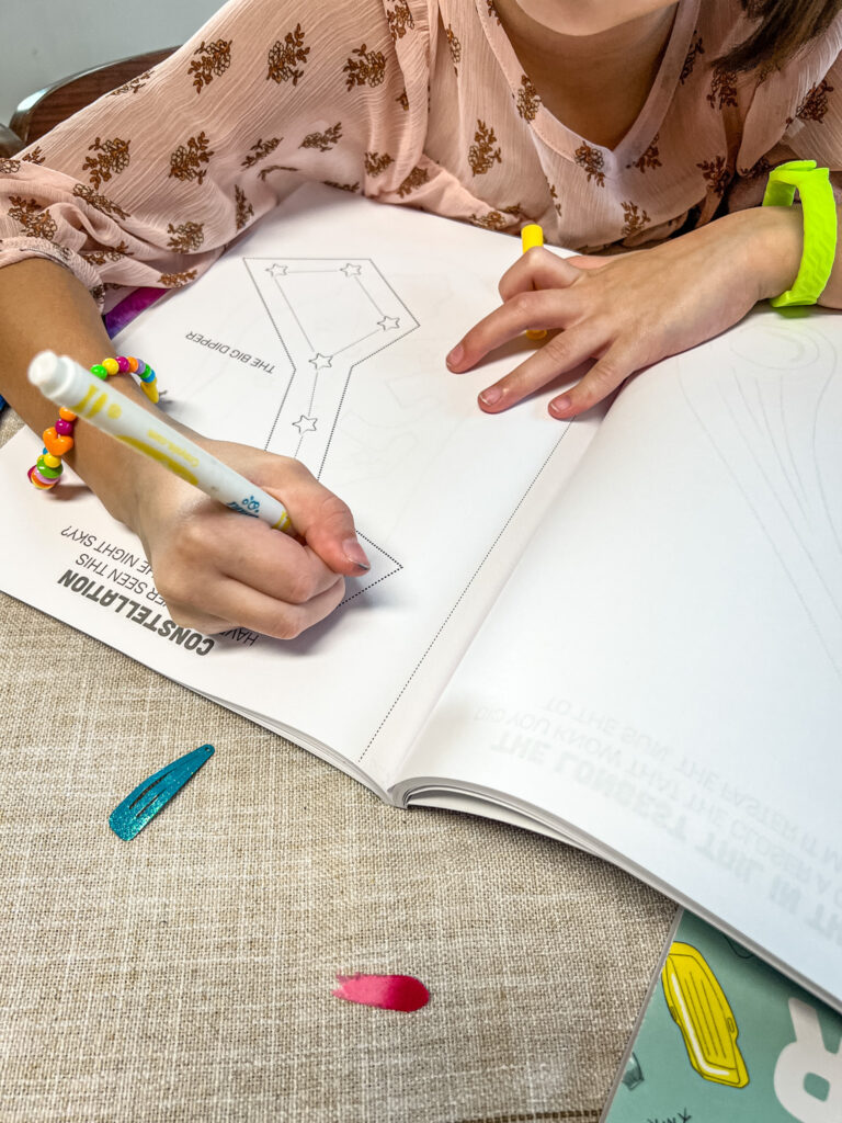 My 7-year-old coloring the stars in the Big Dipper Constellation of the color, cut, & create space book.