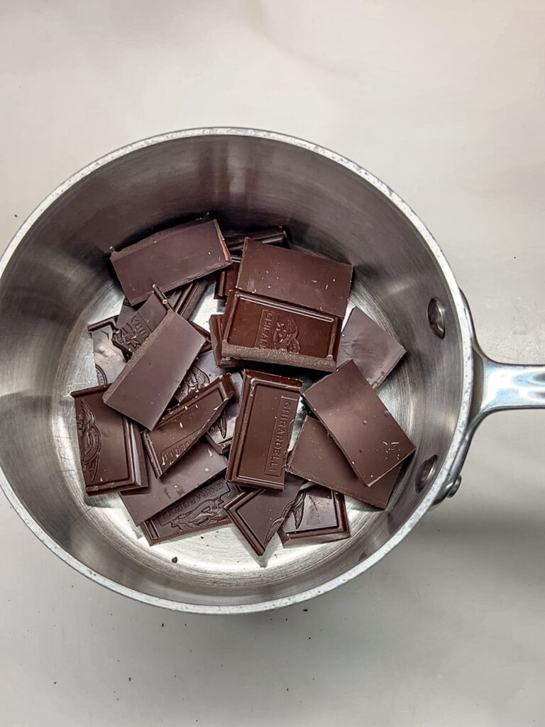 Broken pieces of chocolate in a sauce pot.