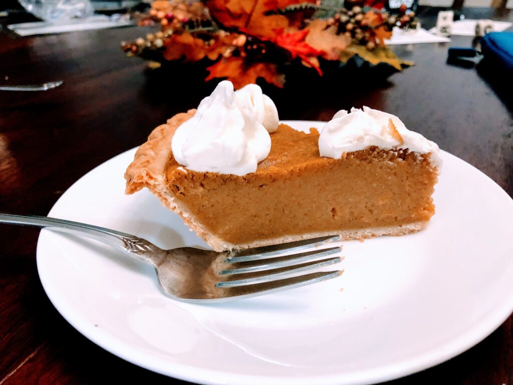 image of a slice of sweet potato pie with marshmallow whipped cream