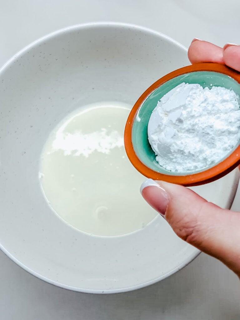 powdered sugar in a terracotta dish right before being poured into the mixing bowl