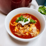 Tortilla soup gumbo "platted". with Rice at the bottom, soup, cheese tortilla strips, sour cream and cilantro.
