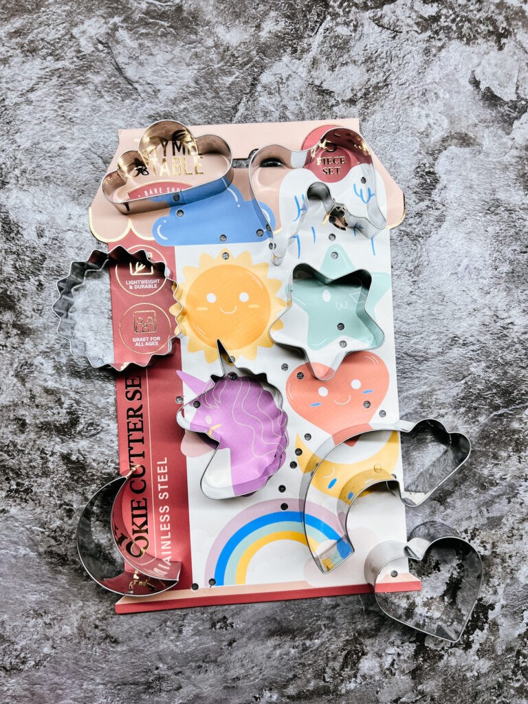 image of the cookie cutter set I bought. The set includes the following shapes: Cloud, Angel Wings, moon, sun, star, unicorn, heart (used for this recipe), and a rainbow with a cloud on the end.