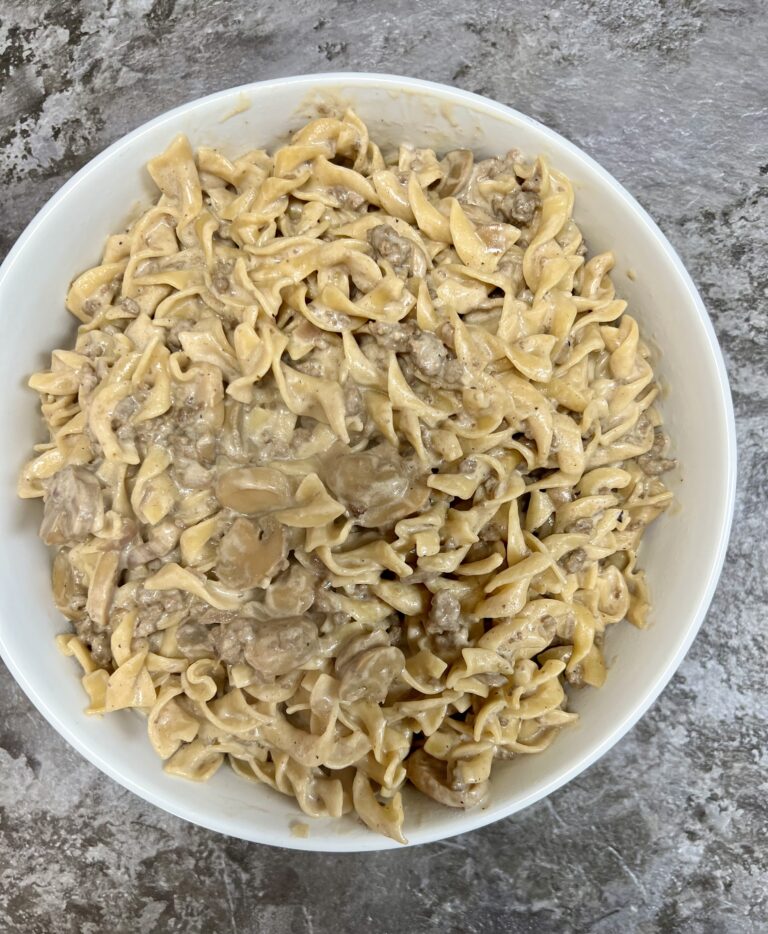 One-Pot Ground Beef Stroganoff in a white serving bowl on a dark granite