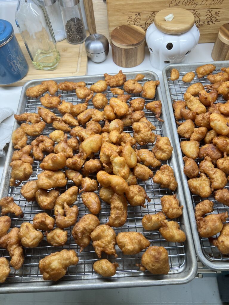 Fried Chicken sitting on a cooling rack in a baking sheet to allow excess oil to drip off