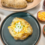 Baked potato with Butter, Cheese, sour cream, and Chives.
