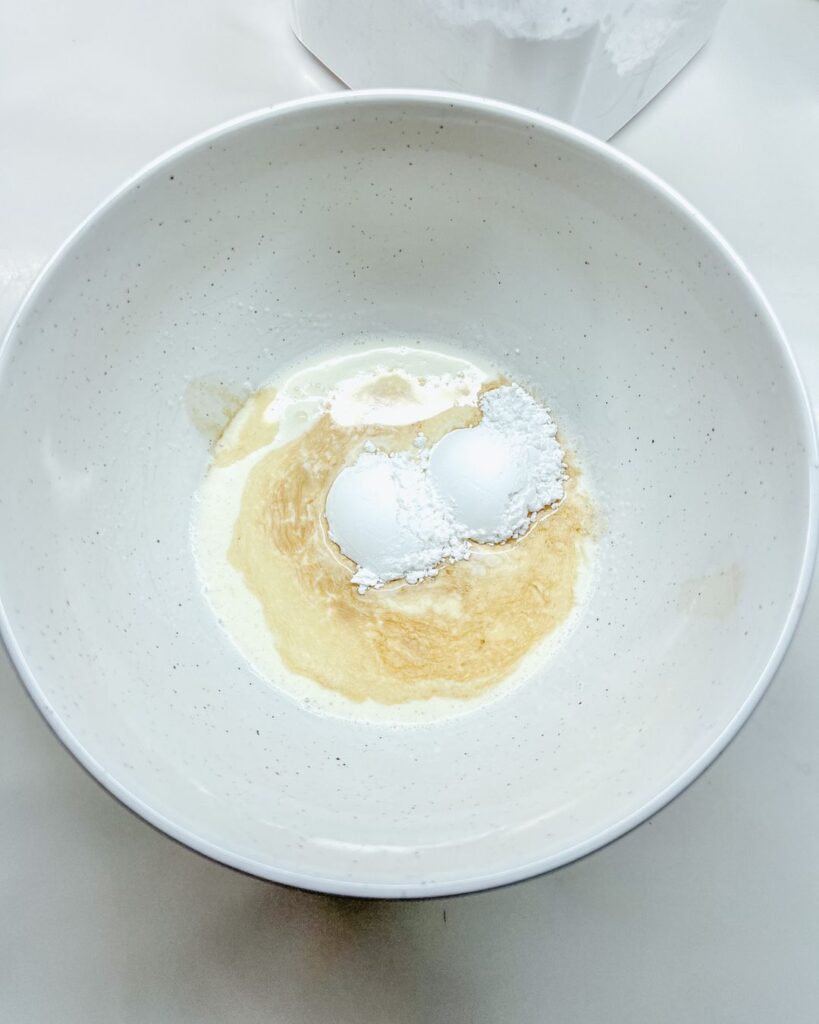 ceramic bowl with whipping cream, vanilla, and powdered sugar.