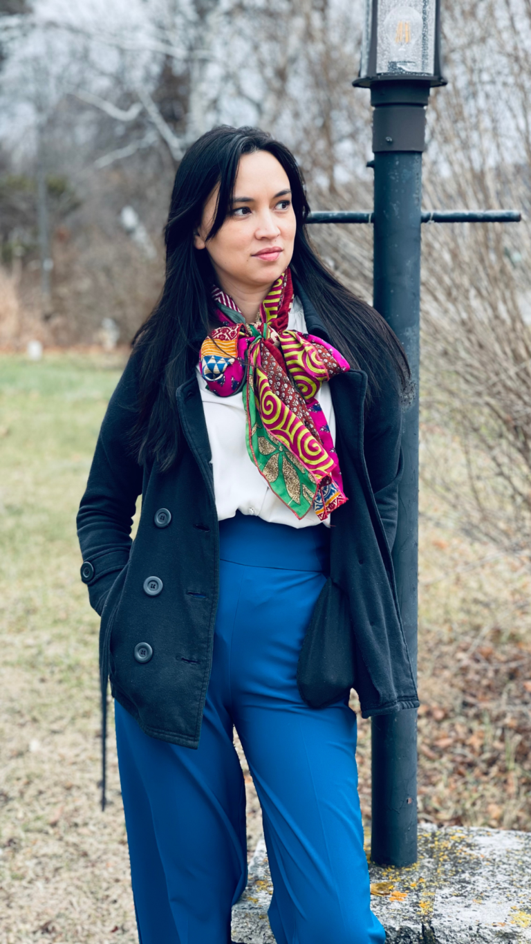this is an image of Jenn Smith (brunette woman) Wear the described outfit and leaning on a light post.