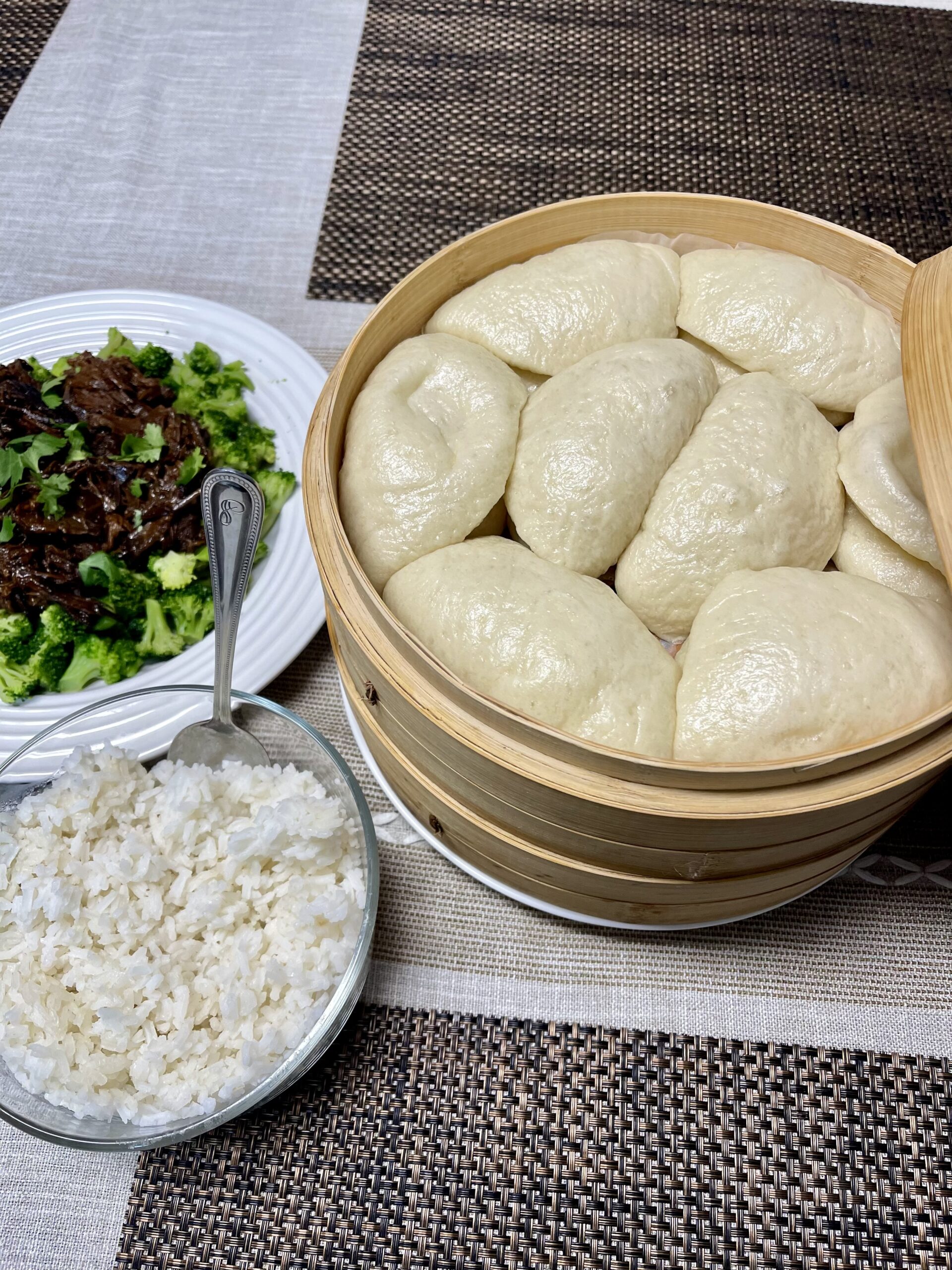 steamed bao buns served with rice and savory Asian-style dishes