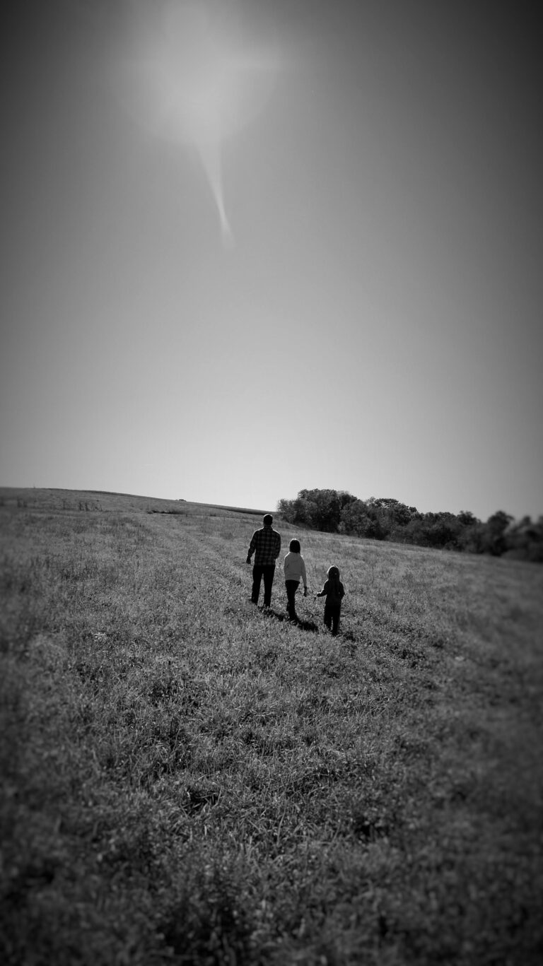 image of my husband and my two older kids in black and white walking up a hill