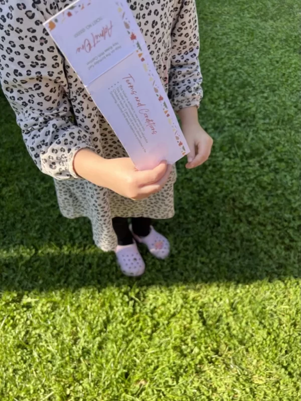 a Younger child holding one of the tickets in their hand.