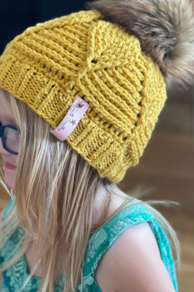 Birch Leaf Beanie toddler size with pom worn by blong child with blue glasses