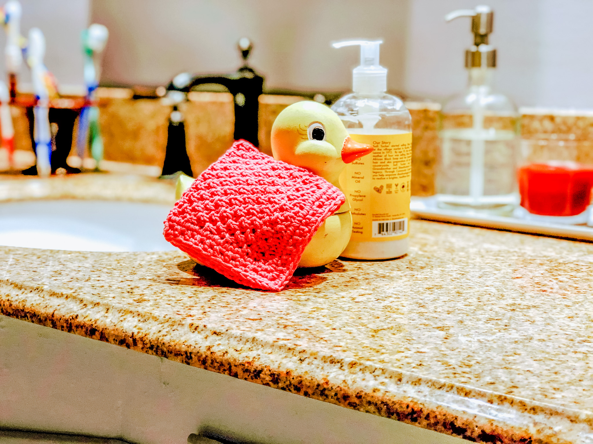 Photo of the pink version of the washcloth with a porcelain duck.