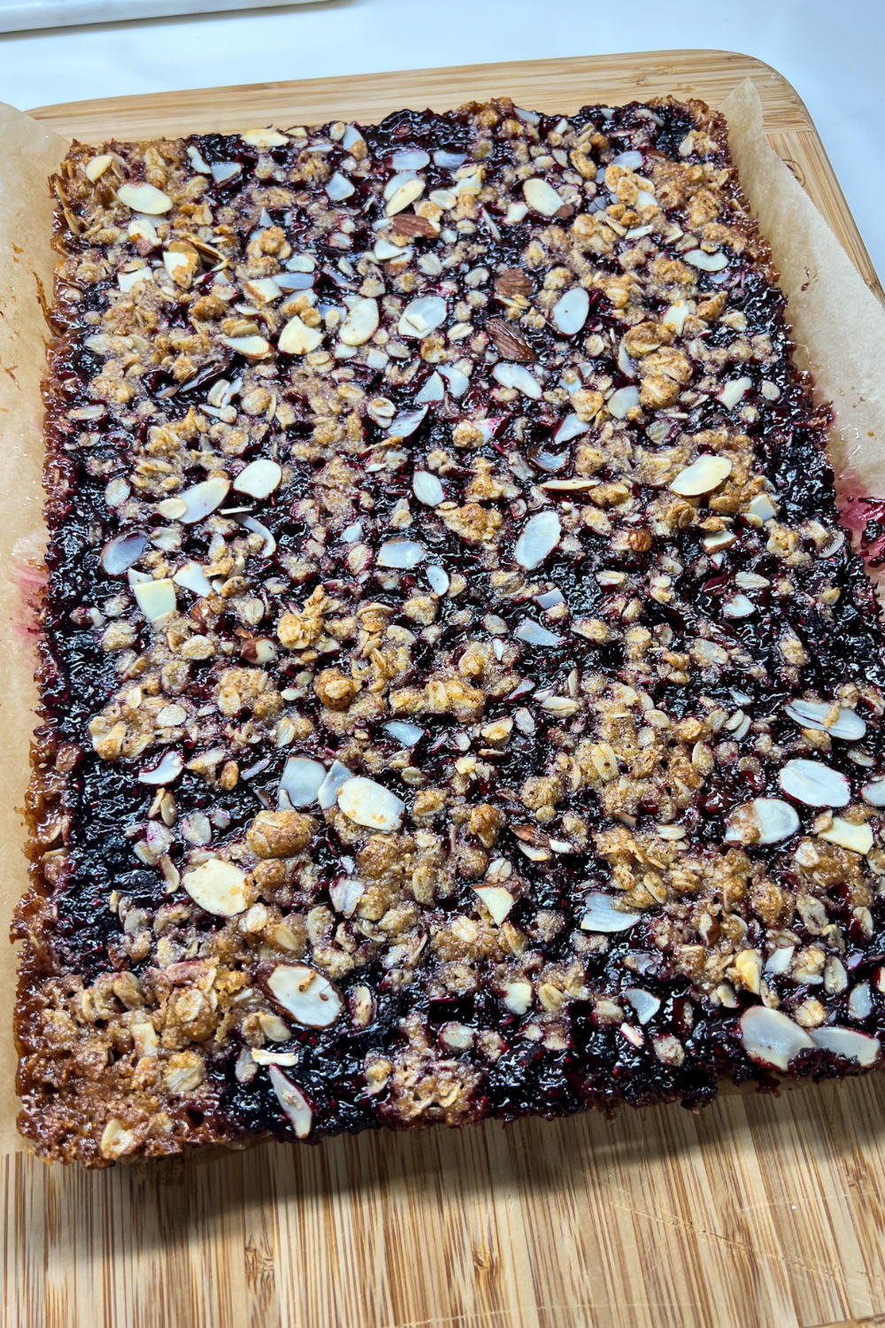 finished Almond Berry Bar on a bamboo cutting board before the bars are cut.