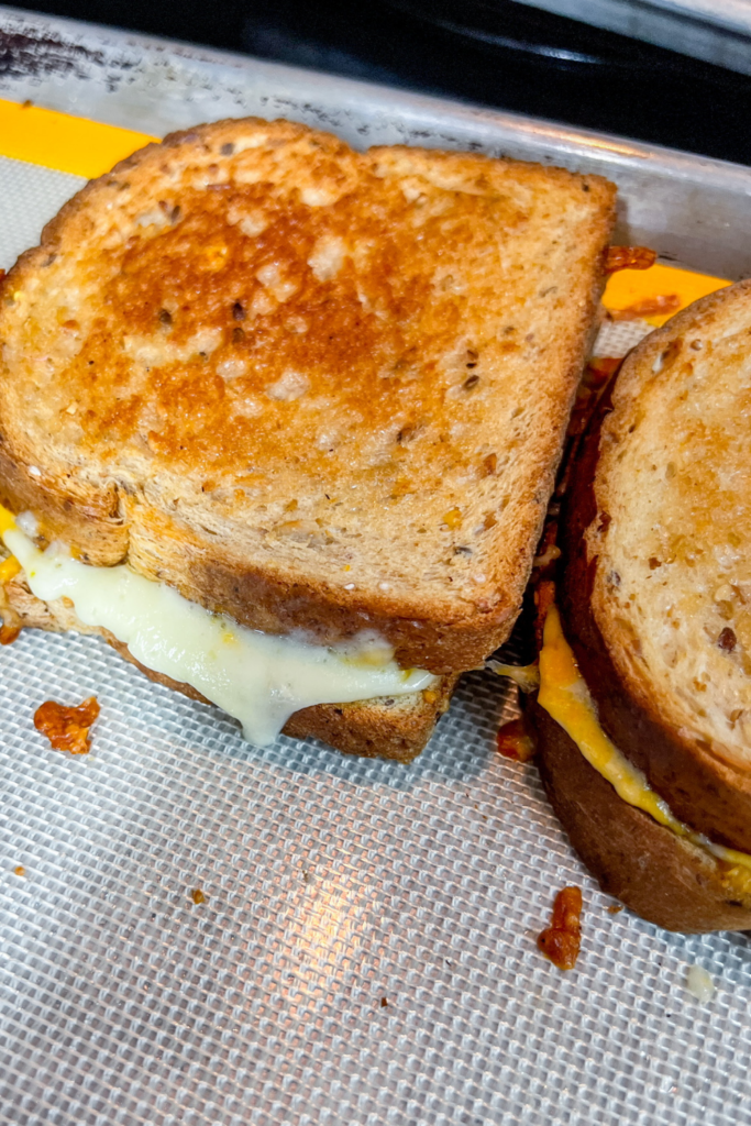 Close up of 2 Finished Grilled Cheeses on the sheet pan.