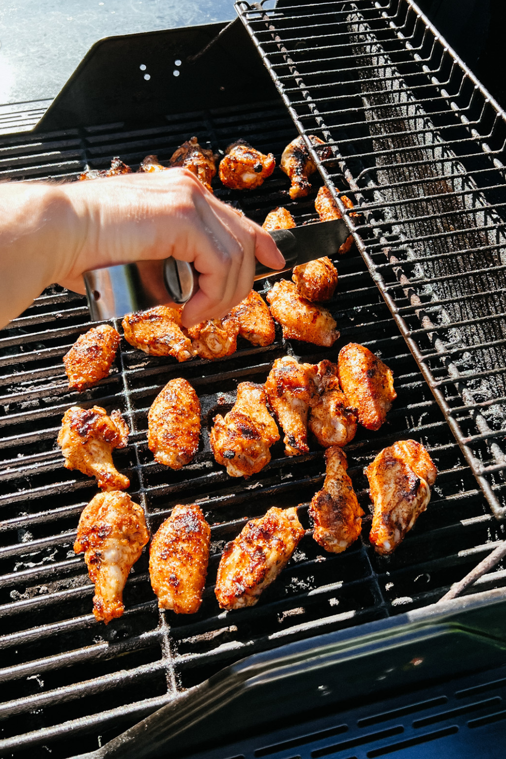 close up image of my husband turning the chicken wings on the grill.