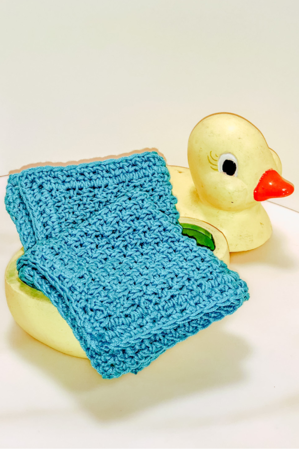 Image of the Finished wash cloth in turquoise on a porcelain yellow duck