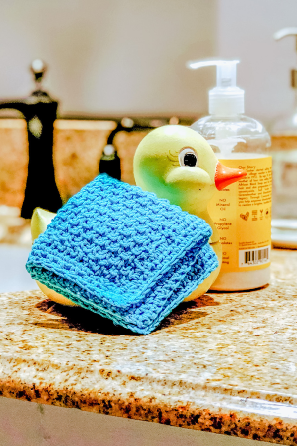 Image of the Finished wash cloth in turquoise on a porcelain yellow duck
