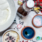 Finished creamer, with empty bowls, crushed peppermint, whipped cream and a finished mocha