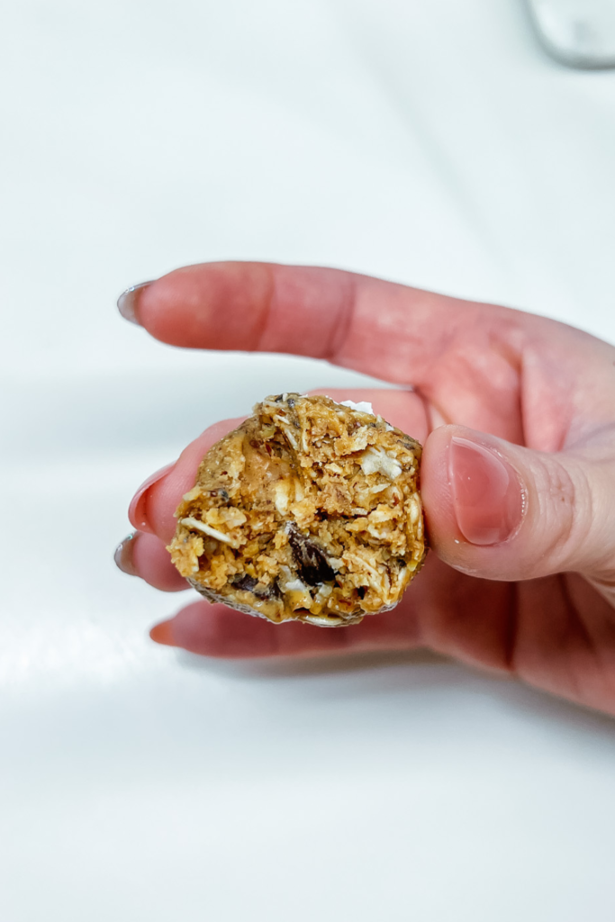 Holding one of the Everyday Energy Snack Bites in my hand after taking a bite to show the inside.