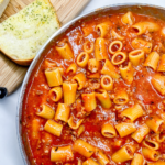 finished One-Pot Rigatoni Ragu next to garlic bread
