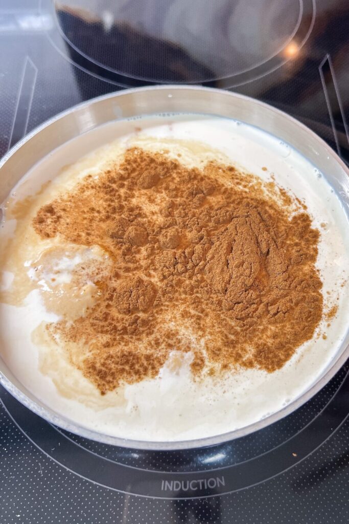 a pot filled with all the Pumpkin Spice Coffee Creamer ingredients on an induction stove.